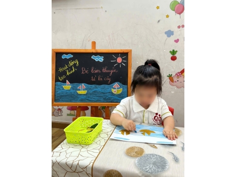 Các bé làm thuyền từ lá cây