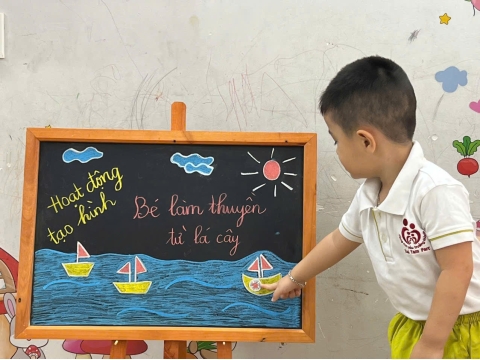 Các bé làm thuyền từ lá cây