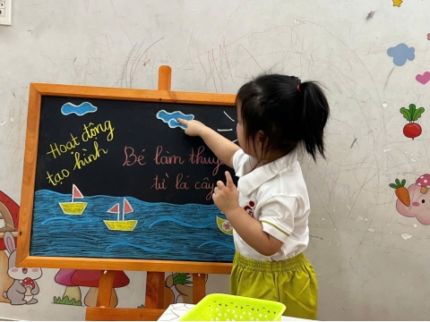 Các bé làm thuyền từ lá cây