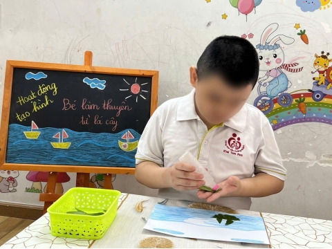 Các bé làm thuyền từ lá cây